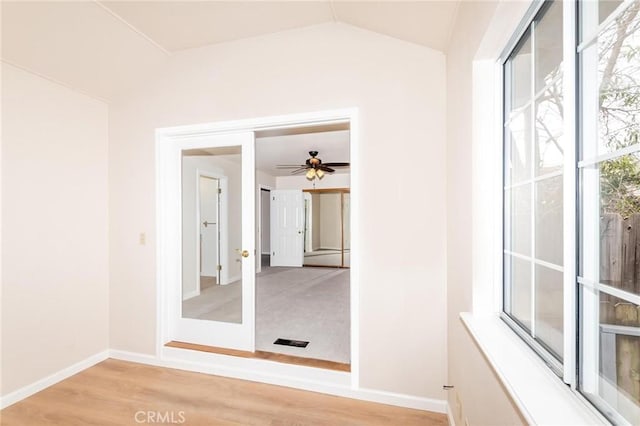 unfurnished room with light wood-style flooring, baseboards, and vaulted ceiling