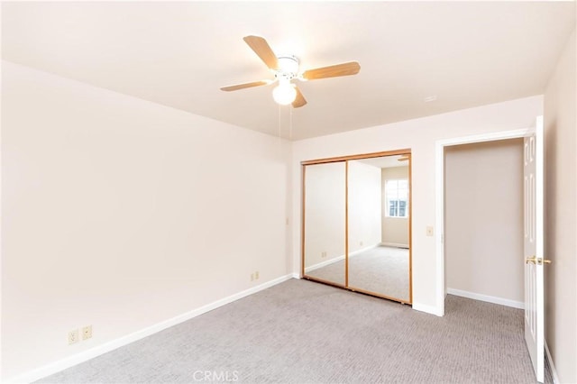 unfurnished bedroom featuring a closet, light carpet, ceiling fan, and baseboards