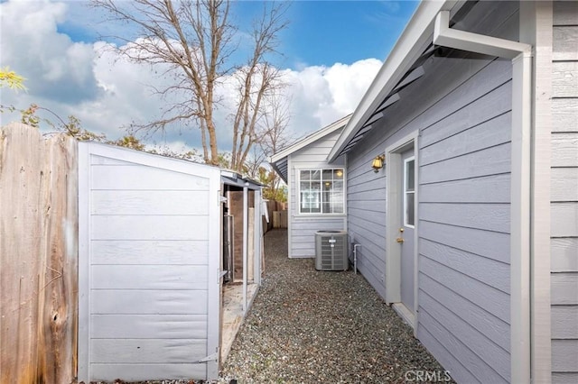 view of property exterior featuring fence and central AC