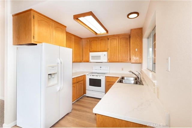 kitchen with light countertops, white appliances, a sink, and brown cabinets