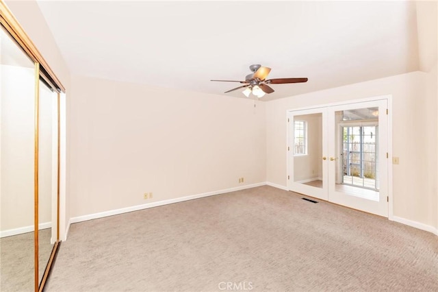 empty room featuring ceiling fan, visible vents, baseboards, french doors, and carpet