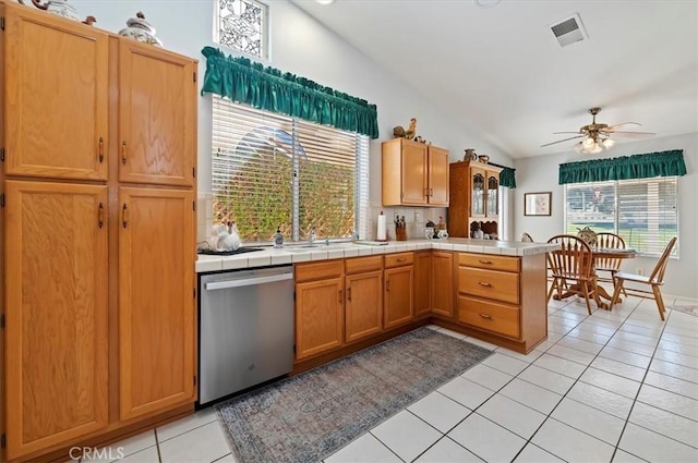 kitchen with tile countertops, light tile patterned floors, visible vents, a ceiling fan, and dishwasher