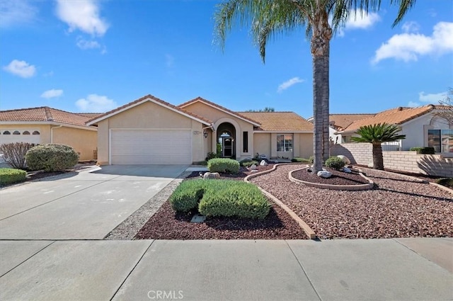 single story home with a garage, concrete driveway, a tile roof, and stucco siding