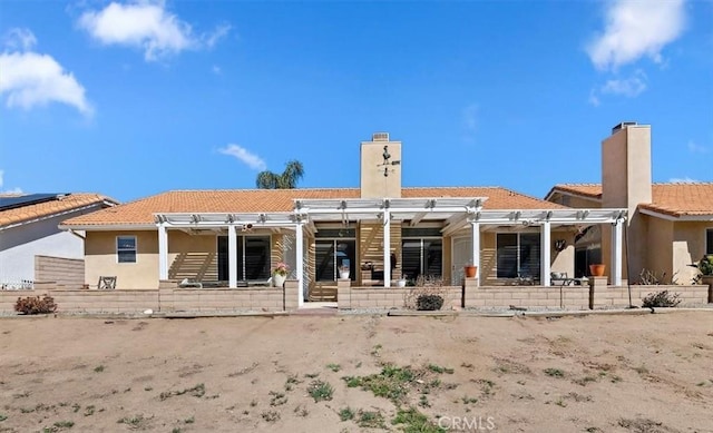 rear view of house with a chimney, a patio area, a tile roof, and a pergola