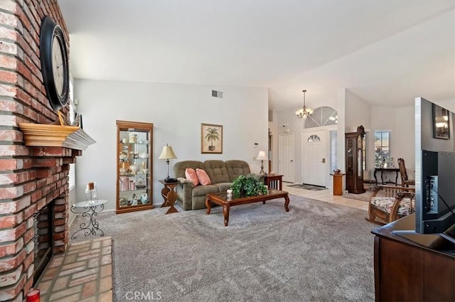 living area featuring visible vents, a brick fireplace, light carpet, vaulted ceiling, and a chandelier