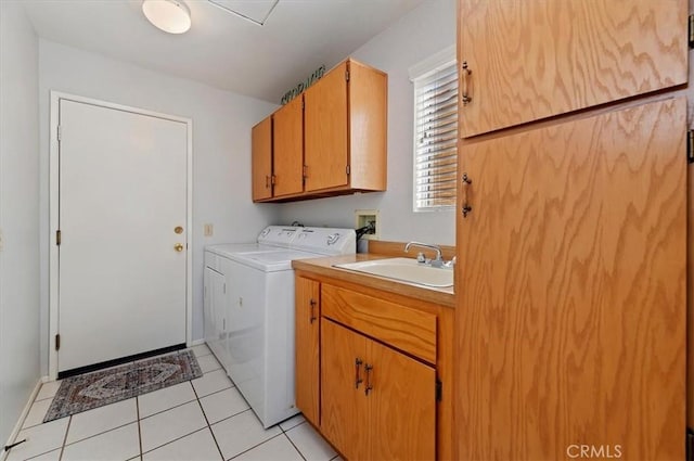 clothes washing area with washer and dryer, cabinet space, a sink, and light tile patterned flooring