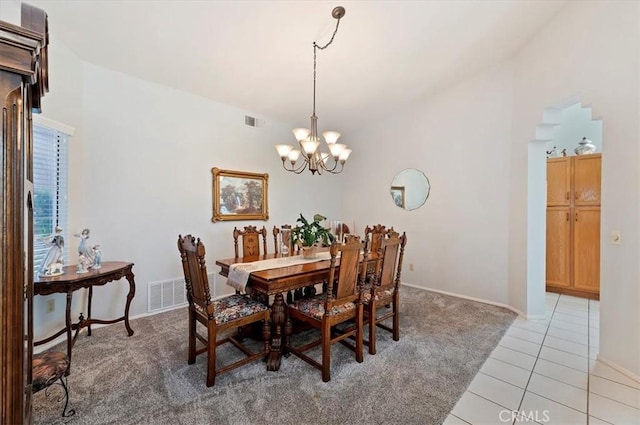 dining area with tile patterned floors, visible vents, and an inviting chandelier