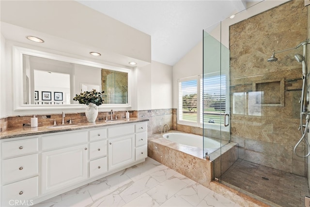 bathroom with marble finish floor, a garden tub, a stall shower, vaulted ceiling, and a sink