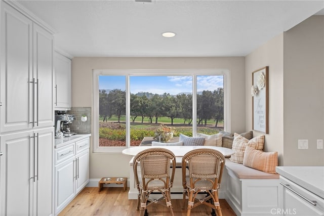 dining area featuring breakfast area, light wood-style flooring, and baseboards