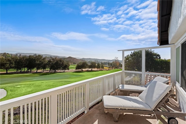 balcony with view of golf course and a mountain view