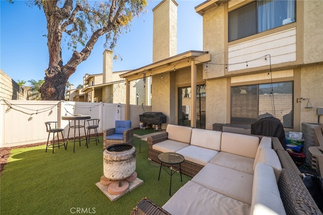 view of patio with an outdoor living space with a fire pit, fence, and area for grilling