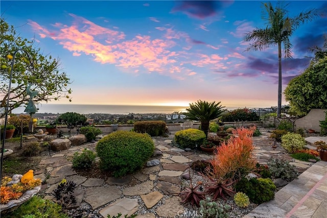 patio terrace at dusk featuring fence