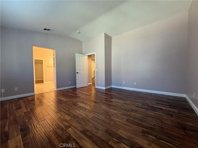 unfurnished bedroom with vaulted ceiling, dark wood finished floors, visible vents, and baseboards