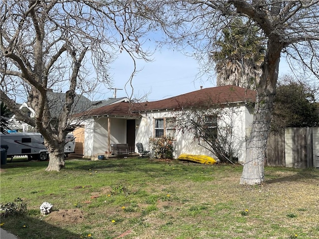 ranch-style house featuring entry steps, fence, and a front yard