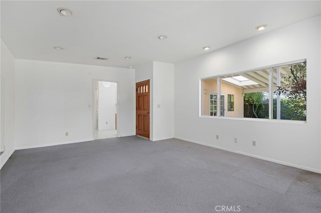 carpeted spare room featuring baseboards, visible vents, and recessed lighting