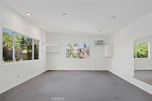 empty room featuring carpet floors, a healthy amount of sunlight, baseboards, and a wall mounted AC