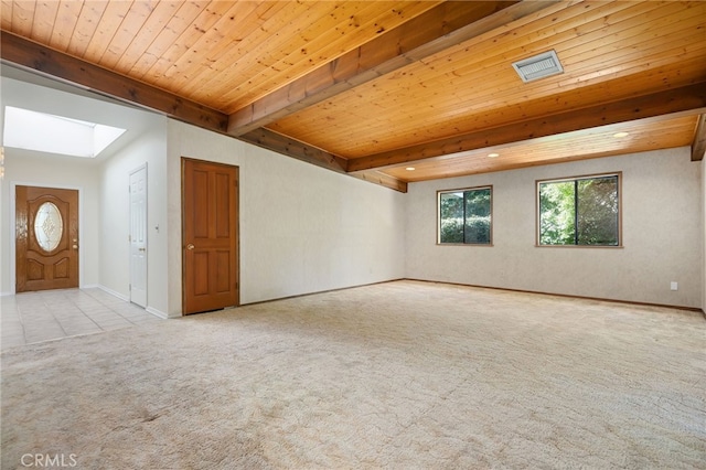 spare room featuring wooden ceiling, light colored carpet, a skylight, baseboards, and beam ceiling