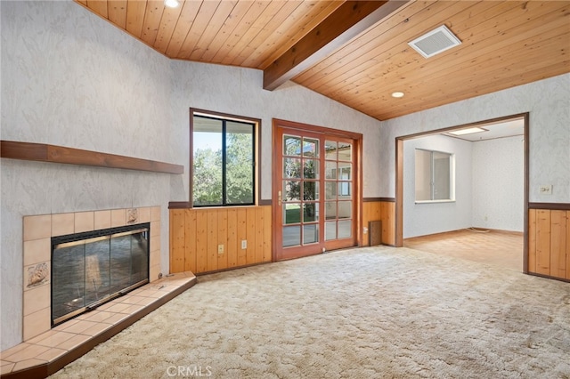 unfurnished living room featuring wooden ceiling, a wainscoted wall, light carpet, a fireplace, and visible vents