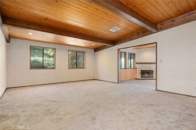 empty room featuring light carpet, wood ceiling, and beamed ceiling