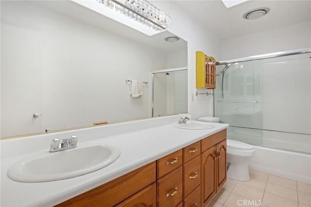 bathroom with a skylight, a sink, and tile patterned floors