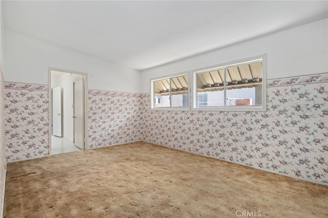 spare room with light carpet and wallpapered walls