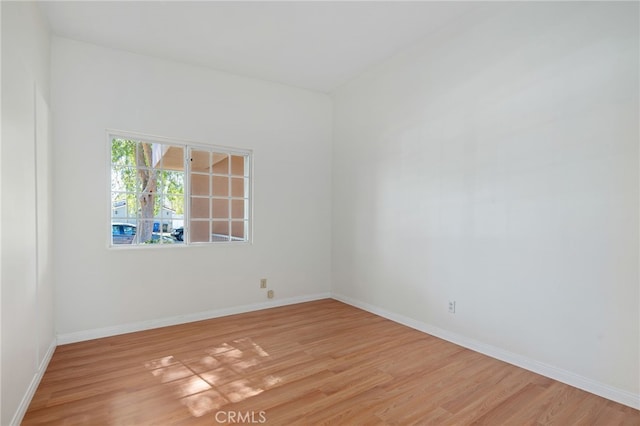 unfurnished room with baseboards and light wood finished floors