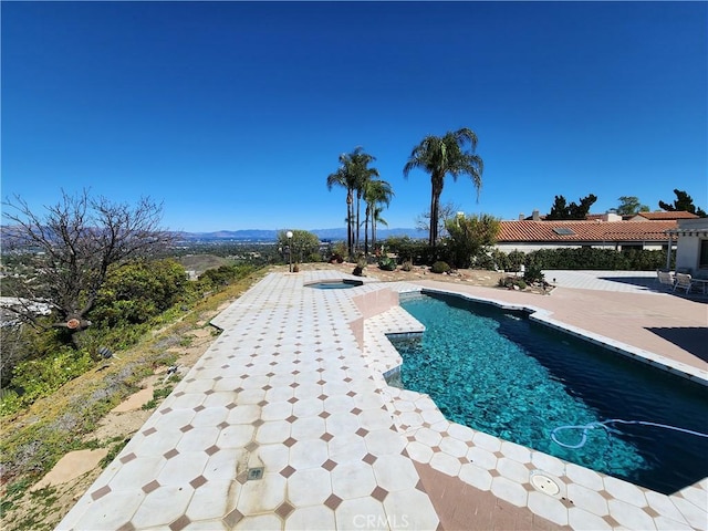 pool featuring a patio area and an in ground hot tub