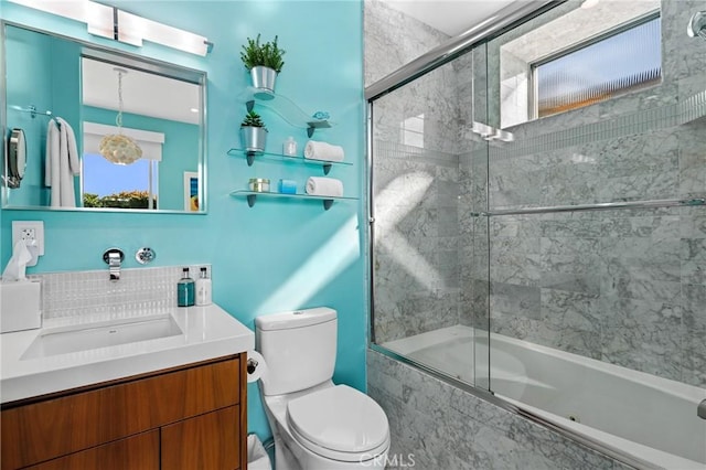 bathroom with vanity, toilet, and bath / shower combo with glass door