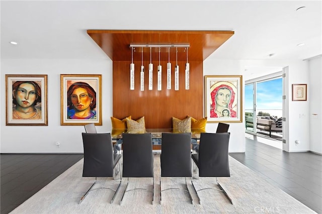 dining space with expansive windows, baseboards, and wood finished floors