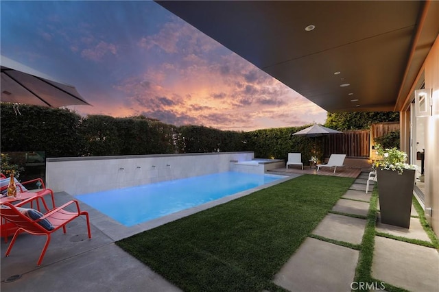 view of swimming pool with an infinity pool, a patio, a yard, and a fenced backyard