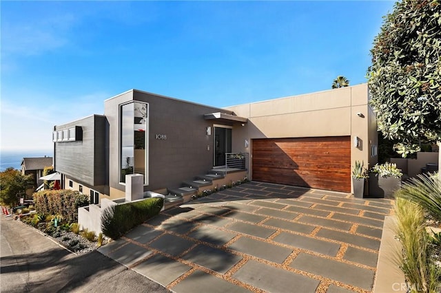 contemporary home with a garage, concrete driveway, and stucco siding