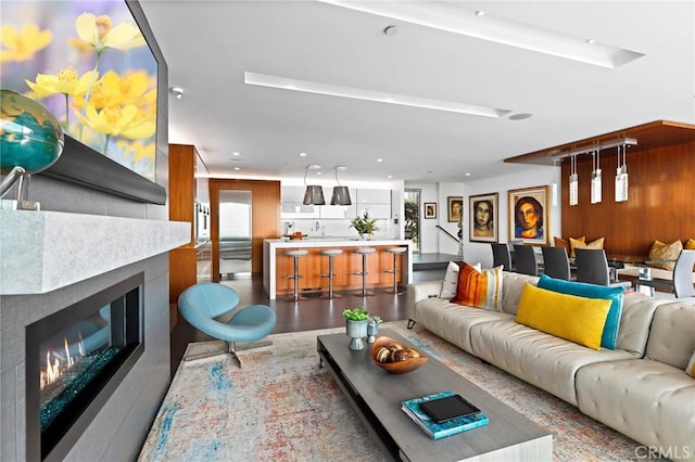 living room with recessed lighting, wood finished floors, and a glass covered fireplace