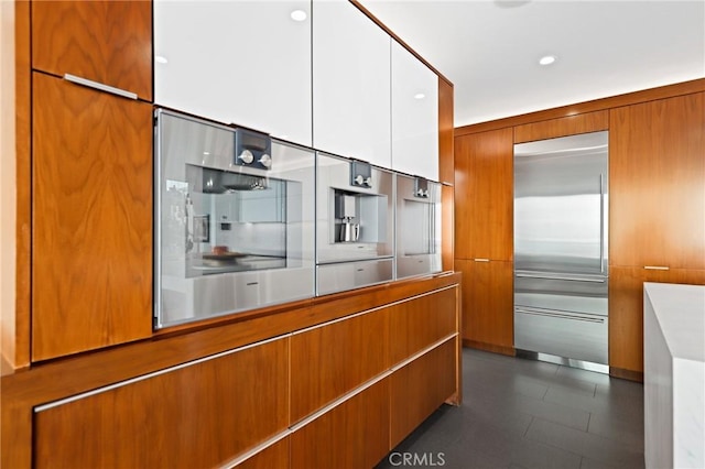 kitchen with stainless steel built in refrigerator, modern cabinets, and brown cabinets