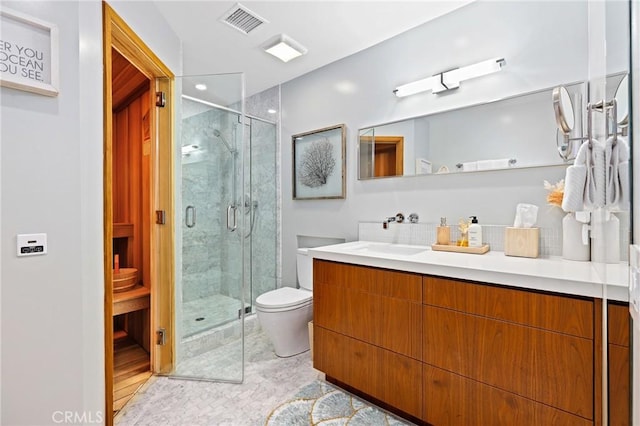 bathroom with toilet, a shower stall, visible vents, and vanity