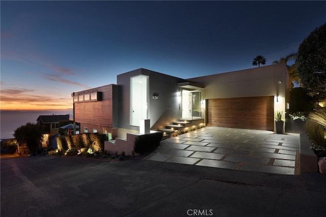 contemporary home with a garage, concrete driveway, and stucco siding