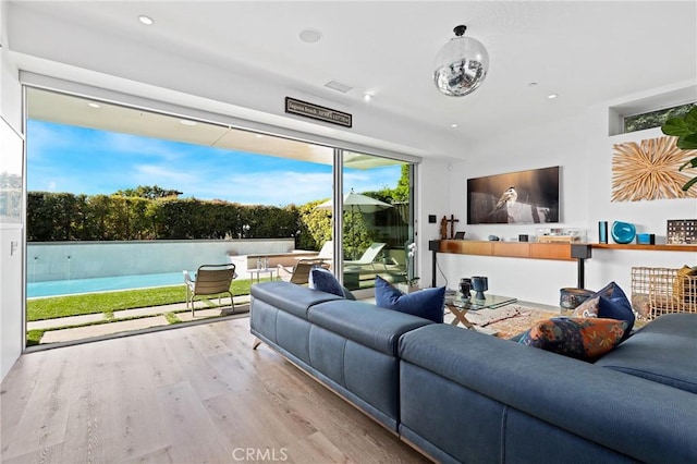 living room with light wood-style floors and recessed lighting