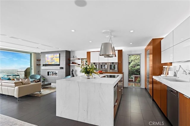 kitchen featuring white cabinets, modern cabinets, light countertops, black appliances, and a sink