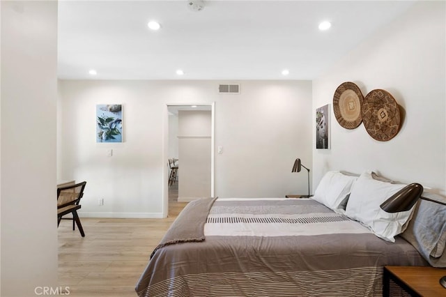 bedroom with light wood finished floors, baseboards, visible vents, and recessed lighting