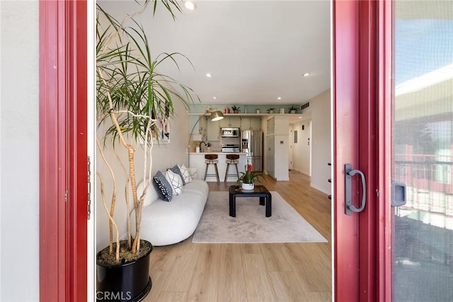 living room featuring light wood-type flooring and visible vents