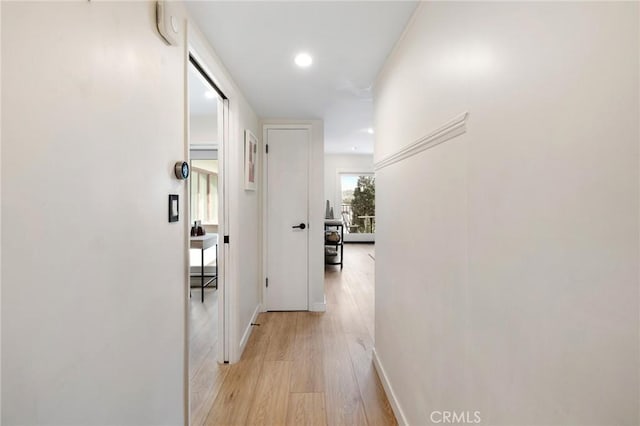 hallway featuring light wood-type flooring, baseboards, and recessed lighting