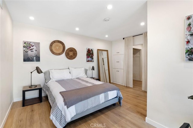 bedroom featuring baseboards, light wood-type flooring, and recessed lighting