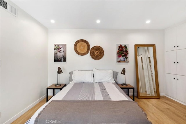 bedroom featuring light wood-type flooring, baseboards, visible vents, and recessed lighting