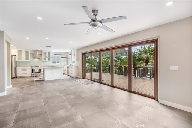 unfurnished living room with recessed lighting, baseboards, and a wealth of natural light