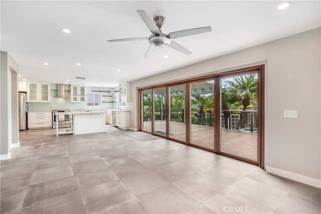 unfurnished living room with baseboards, a ceiling fan, and recessed lighting
