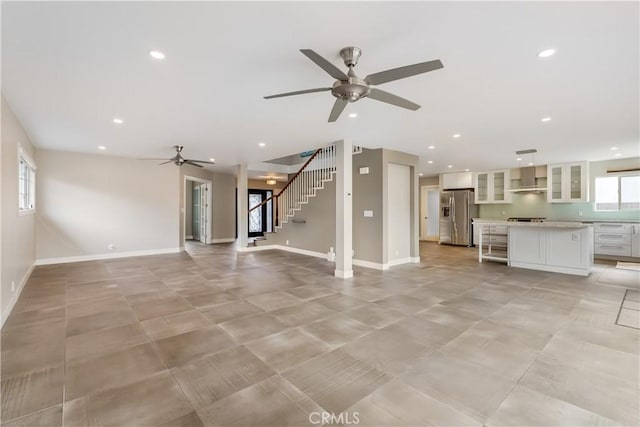 unfurnished living room with recessed lighting, stairway, baseboards, and a ceiling fan