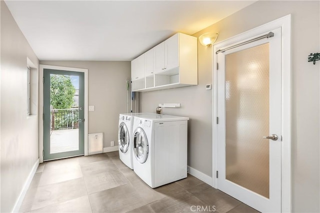 laundry room featuring washer and clothes dryer, cabinet space, and baseboards