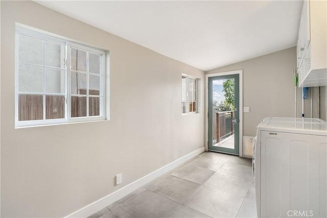 clothes washing area with baseboards, washer / dryer, light tile patterned flooring, and laundry area