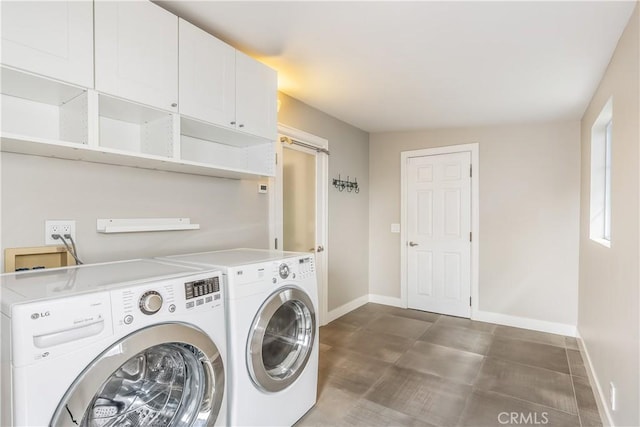 laundry area with cabinet space, independent washer and dryer, and baseboards