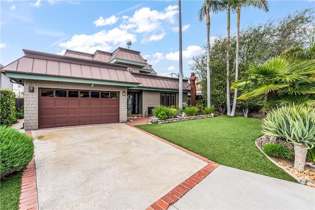 view of front of home with a front yard, metal roof, driveway, an attached garage, and a standing seam roof