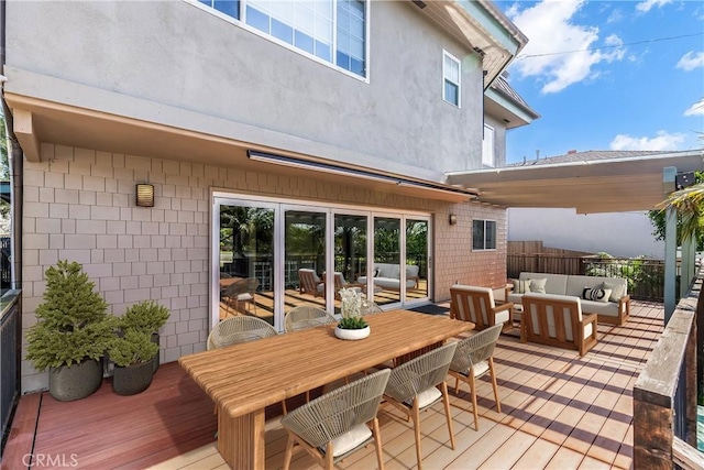 wooden terrace with outdoor dining area, fence, and an outdoor hangout area